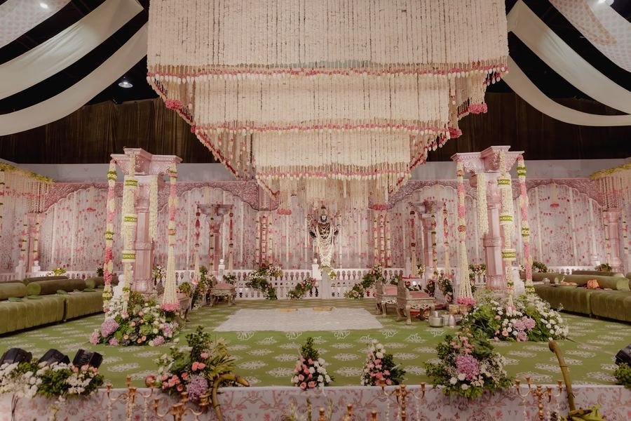 Pink and white garland mandap with a strand chandelier