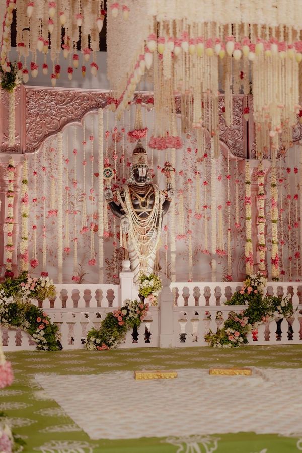 Deity framed by blush and white garlands