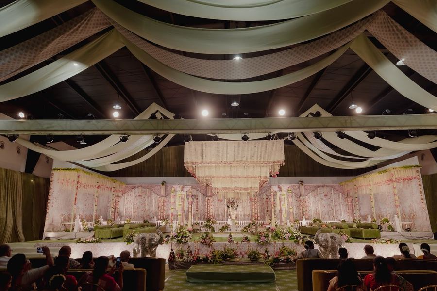 Hall view of the blush mandap beneath draped ceiling