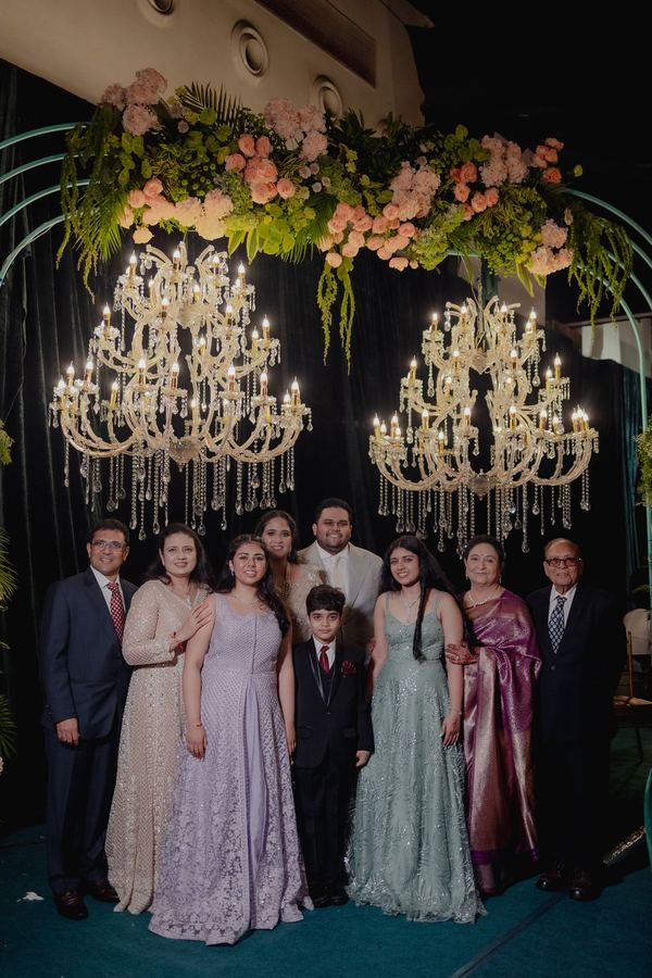 Family beneath chandeliers and a floral crown