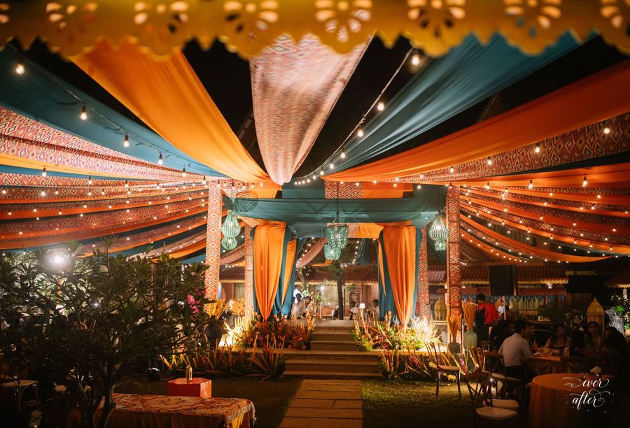 Teal and saffron draped canopy with festoon lights
