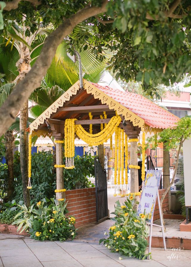 Tiled garden hut draped in yellow marigold strands
