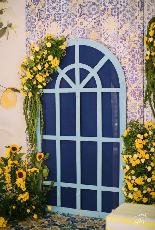 Blue arched window framed in sunflowers and blue tiles