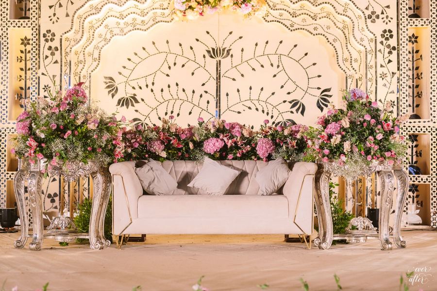 Reception lounge with ivory sofa before a carved jaali screen