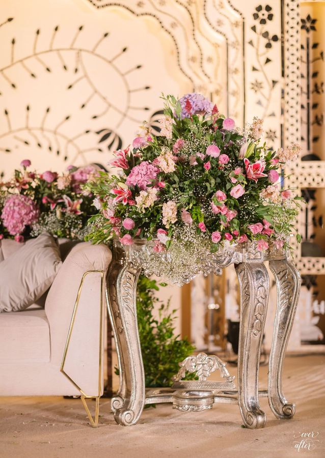 Pink rose arrangement on an ornate silver pedestal