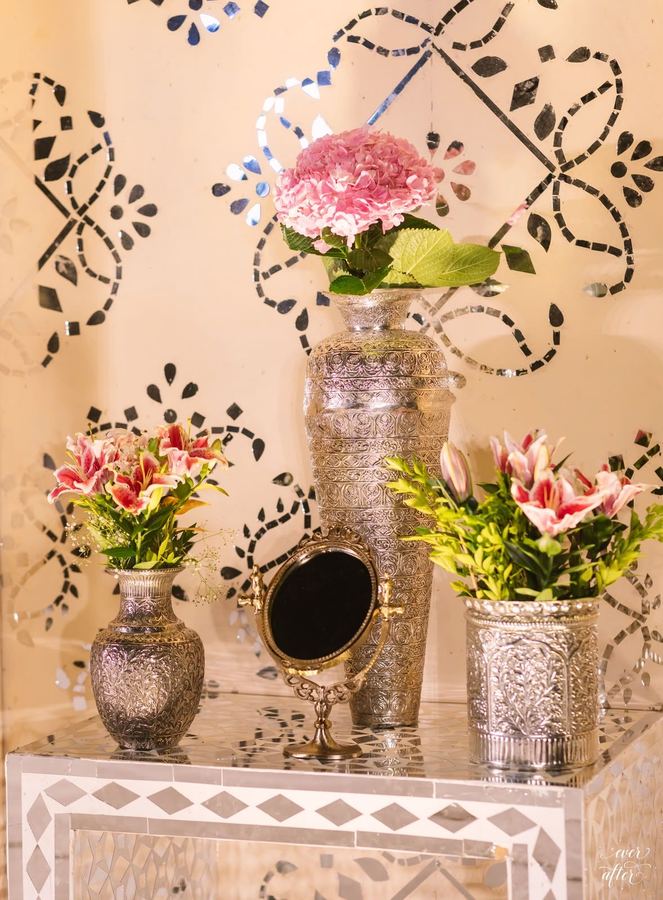 Lilies and roses in etched silver vessels