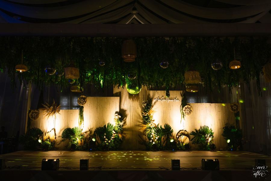 The sangeet stage glowing at night under hanging greenery