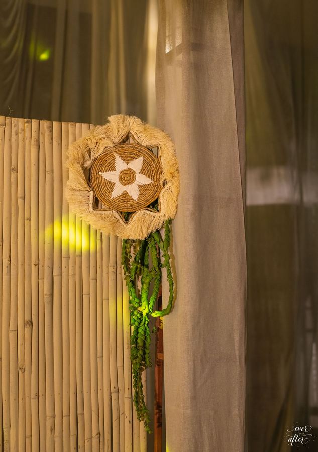 Woven star ornament with hanging greenery on bamboo