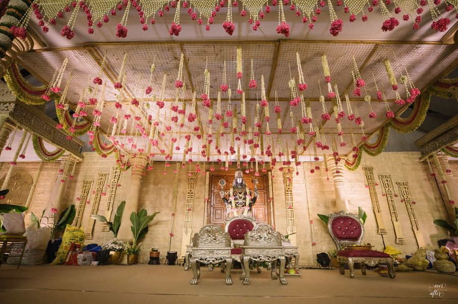 Ceremony stage with carved throne chairs and floral strands