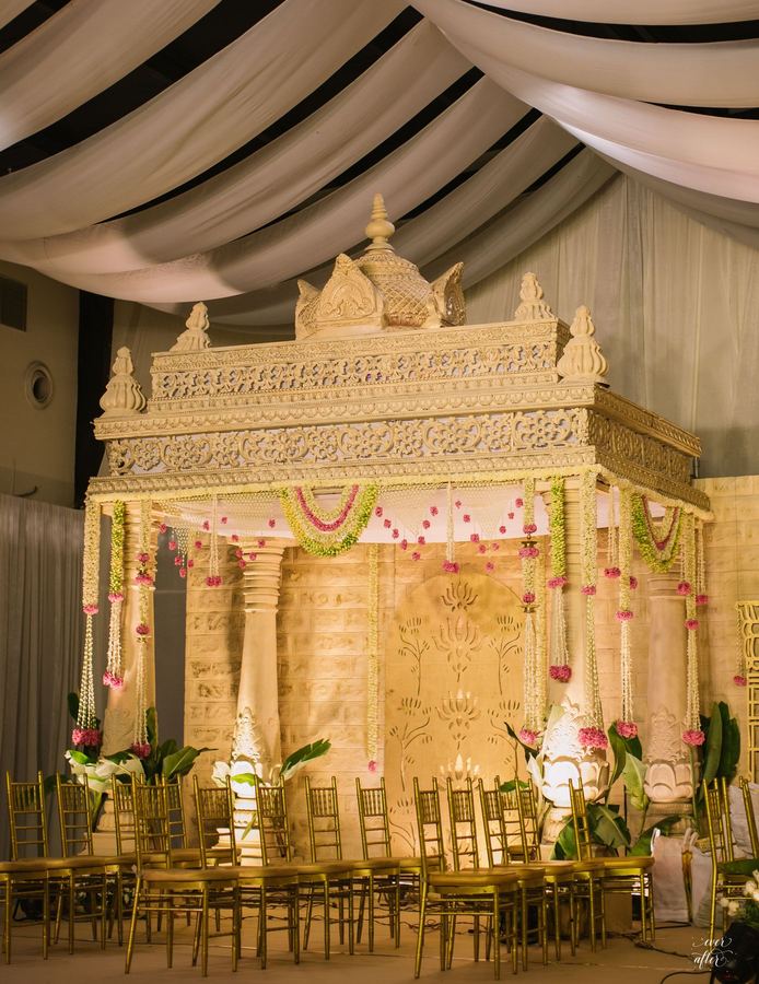 Ivory mandap with gold chiavari chairs set for guests
