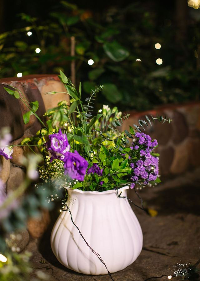 Purple blooms in a fluted white vase
