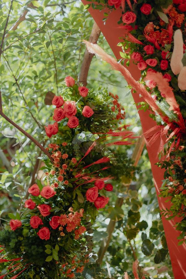 Red roses and greenery on the coral backdrop