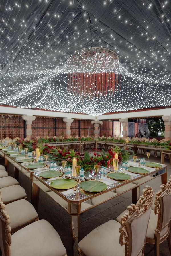 Long dinner table under a canopy of fairy lights