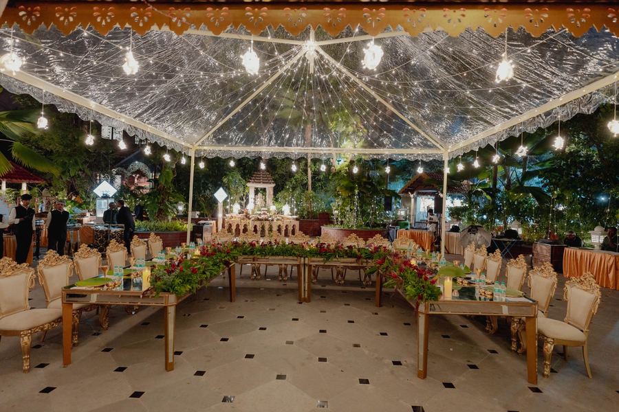 U-shaped dinner under a clear pavilion with bulb lights