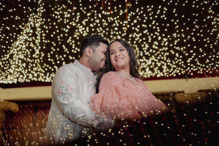 Couple seated before a wall of fairy lights
