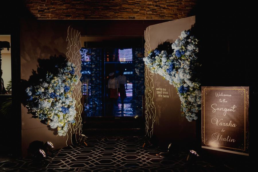 Entrance doors framed in blue hydrangeas with a welcome sign