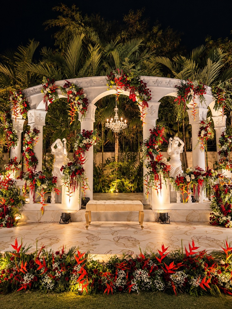 Classical white stone gazebo styled with red floral draping