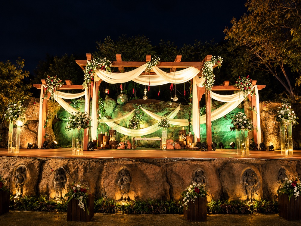 Rustic wooden pergola draped in white fabric for a ceremony