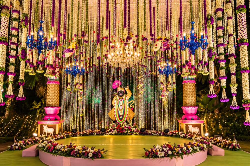 Circular stage with hanging floral strands and blue chandeliers